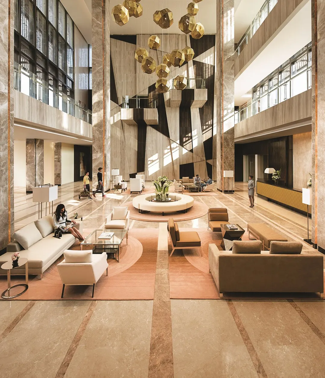 A grand atrium lobby with a concierge desk and lounge seating